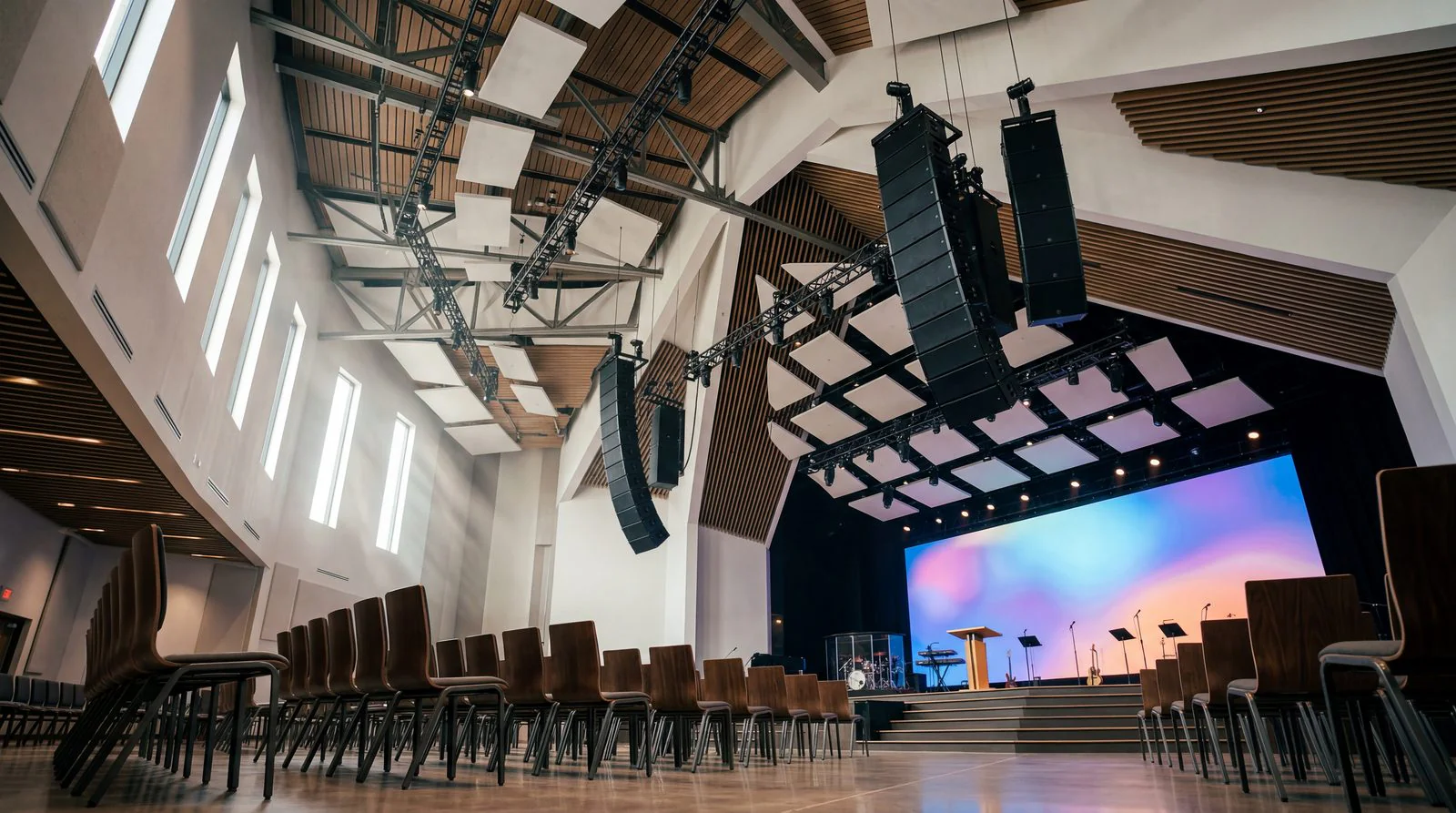 A house of worship sanctuary with stage lighting and a video wall