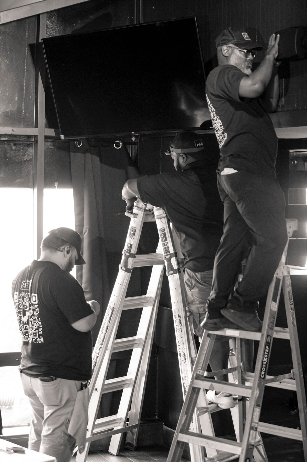 PAVE technicians installing a display and speaker on site