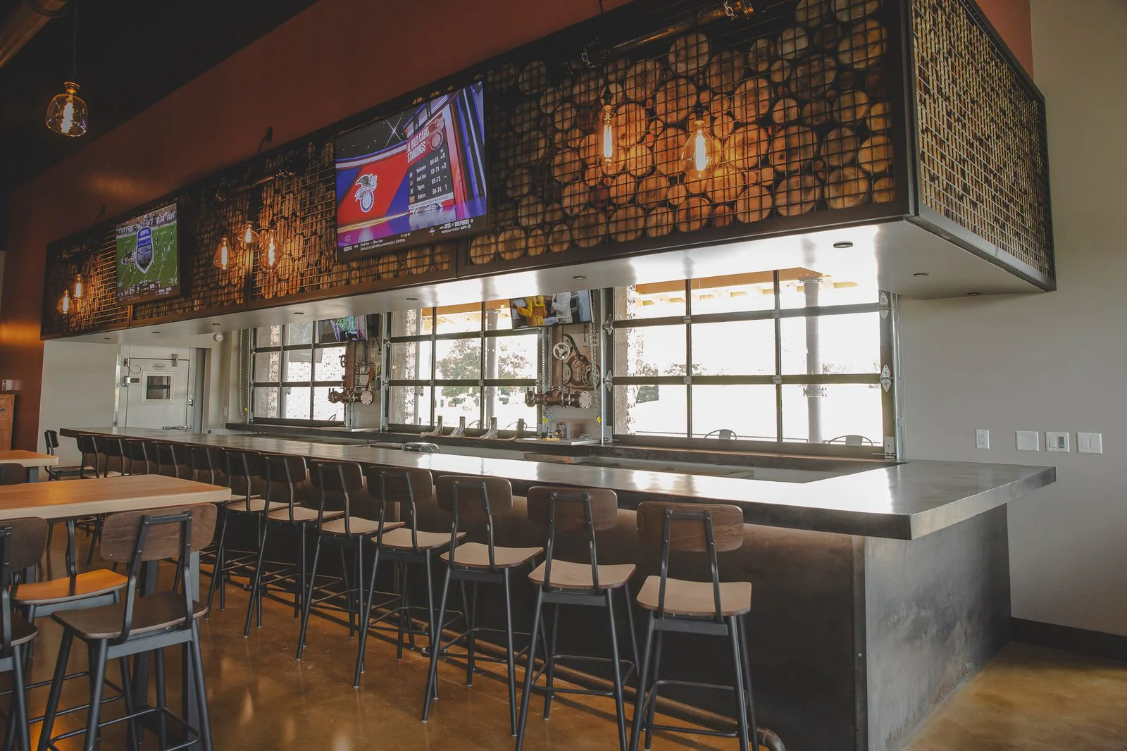 A hospitality bar with wall-mounted displays and zoned audio
