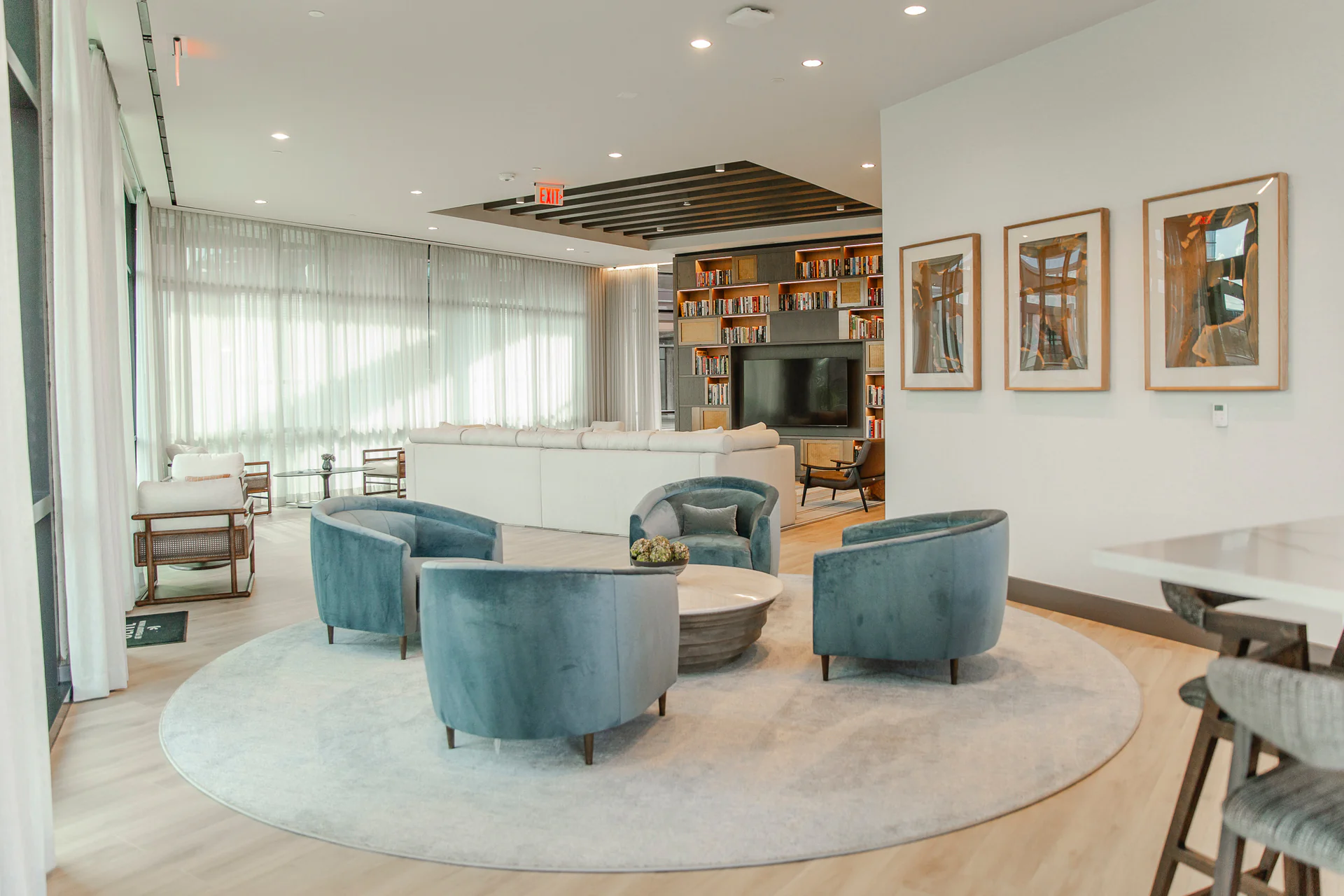 The Peabody resident lounge with a wall-mounted display and library wall