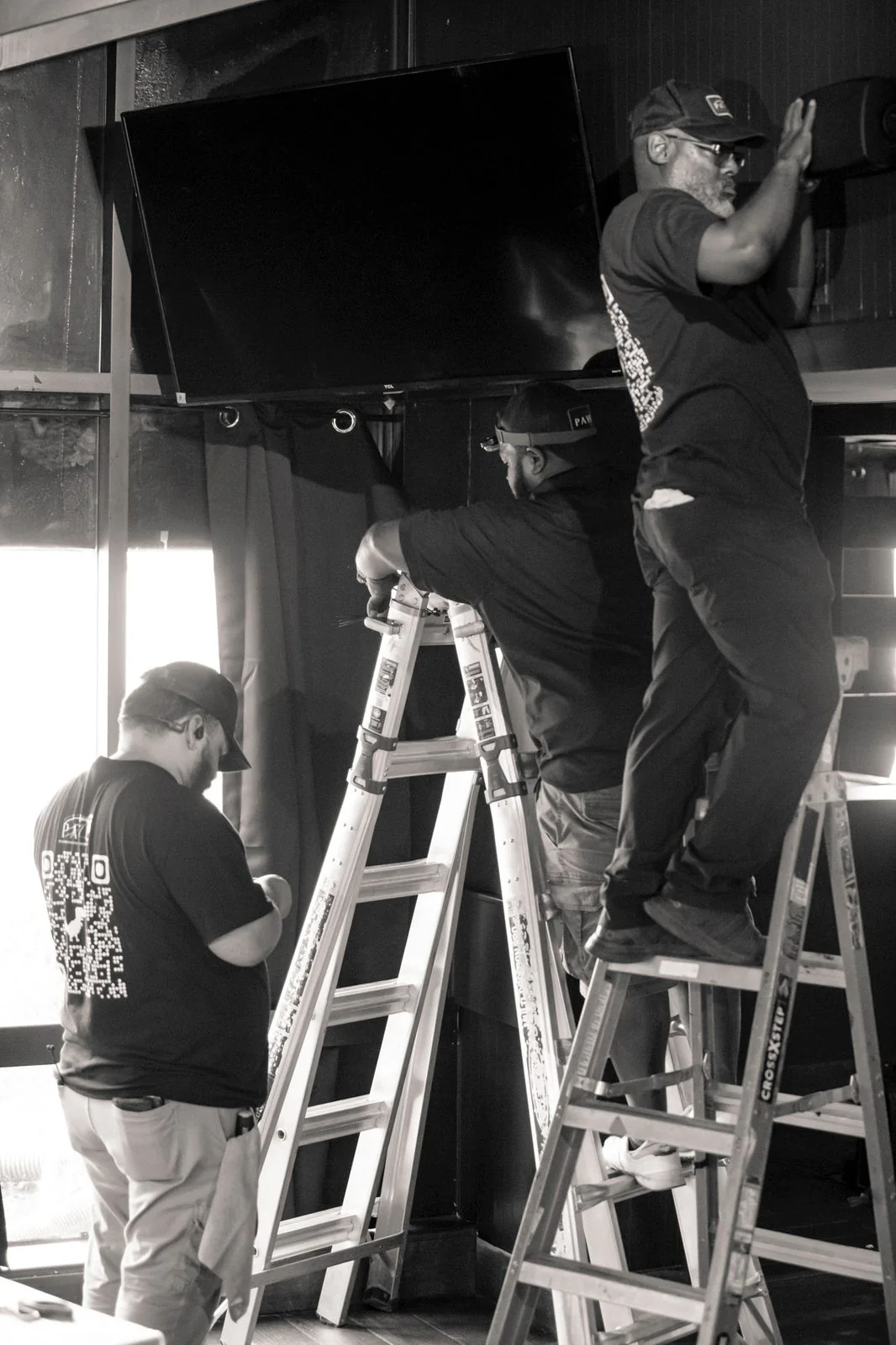 PAVE technicians installing a display and speaker on site