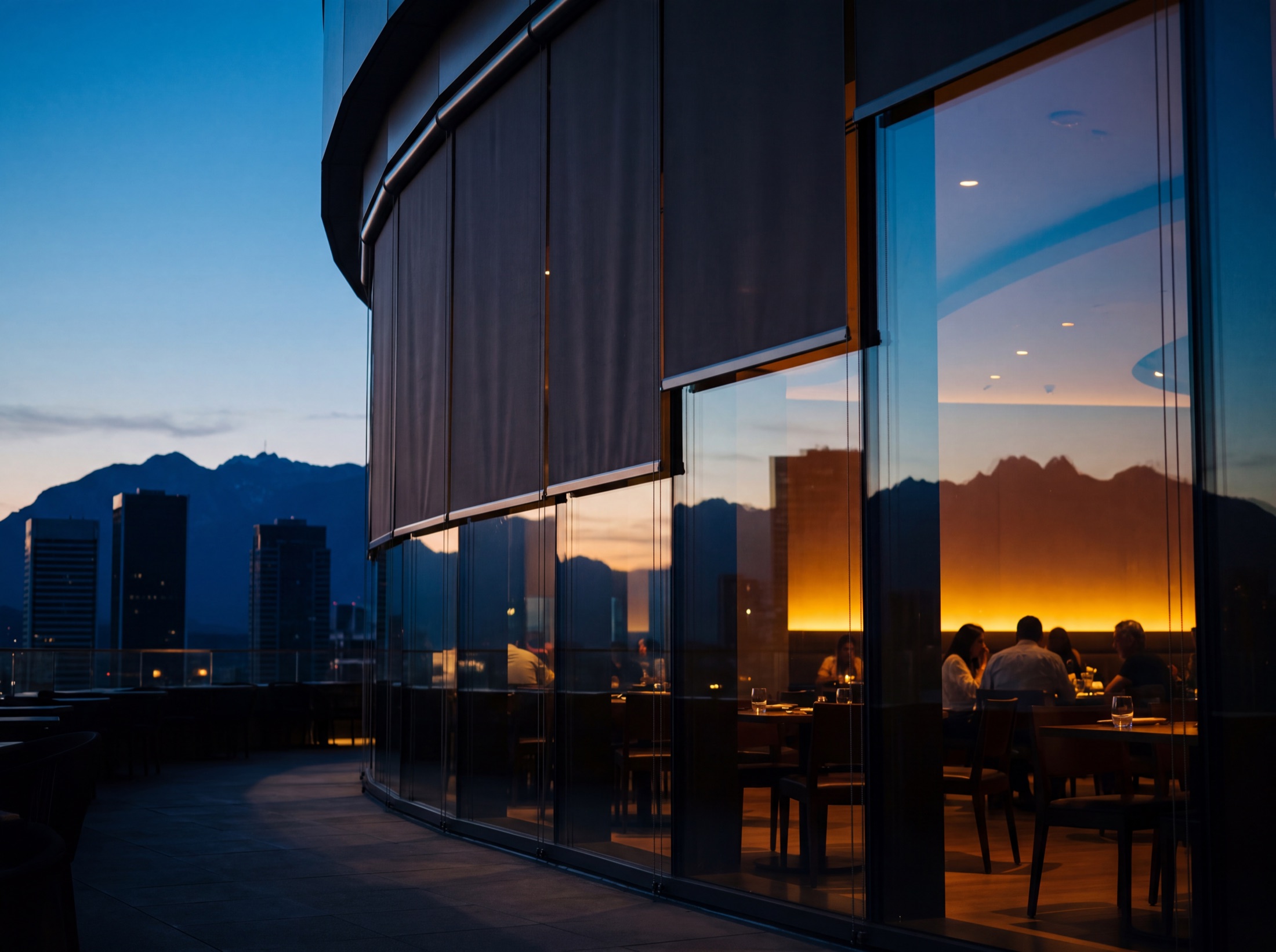 Hospitality glass at dusk, shades lifting in unison as the sun releases the facade and the room opens to the view