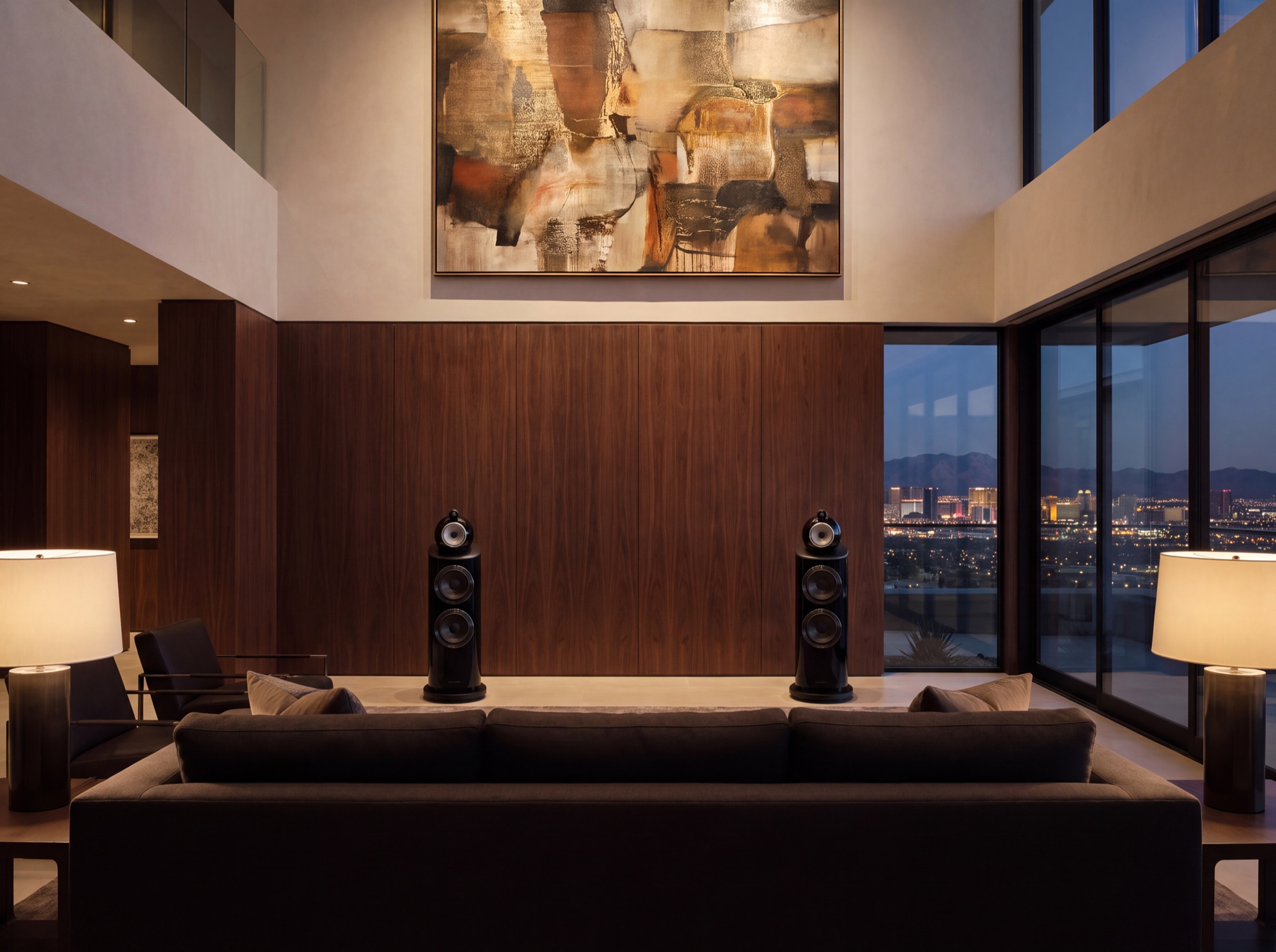 Statement floorstanding loudspeakers set symmetrically against a walnut wall, firing across to the seating that faces them