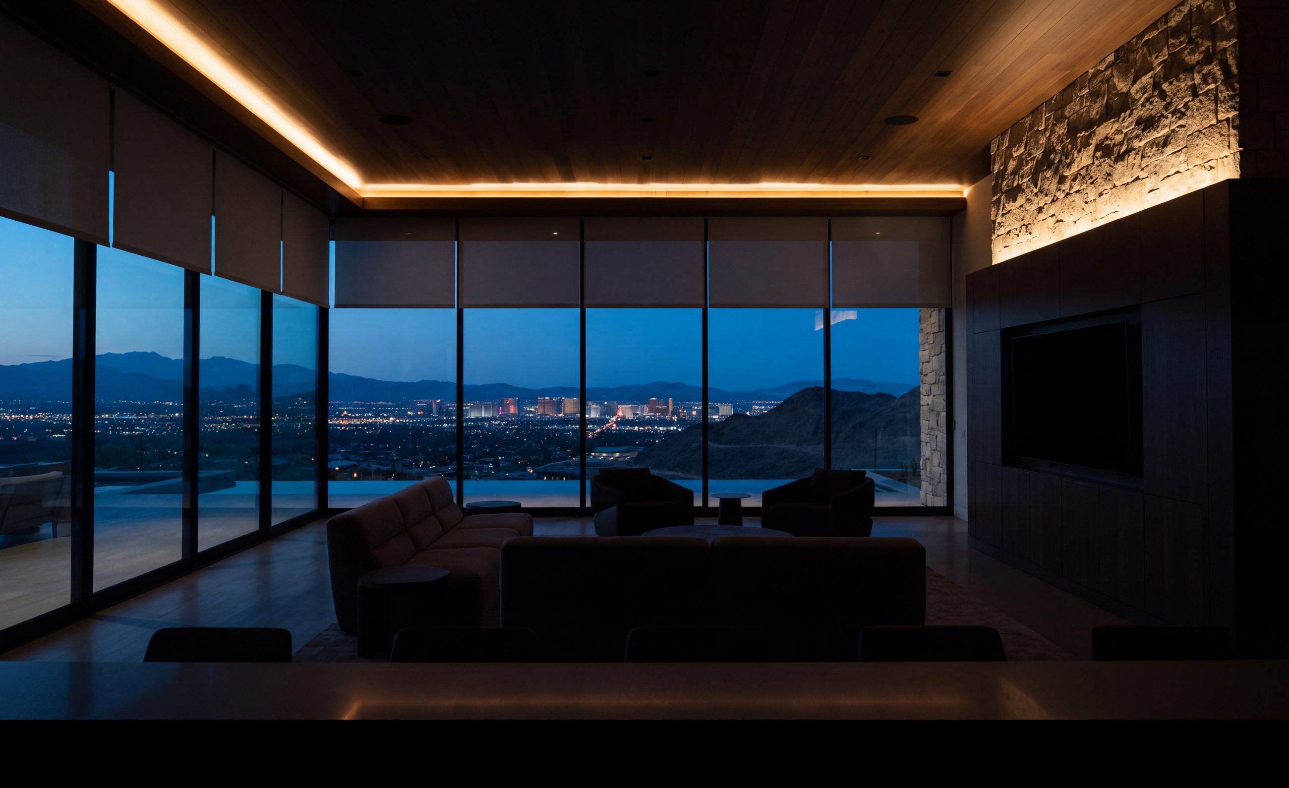A great room at dusk, shades settled at one height, the valley beyond the glass