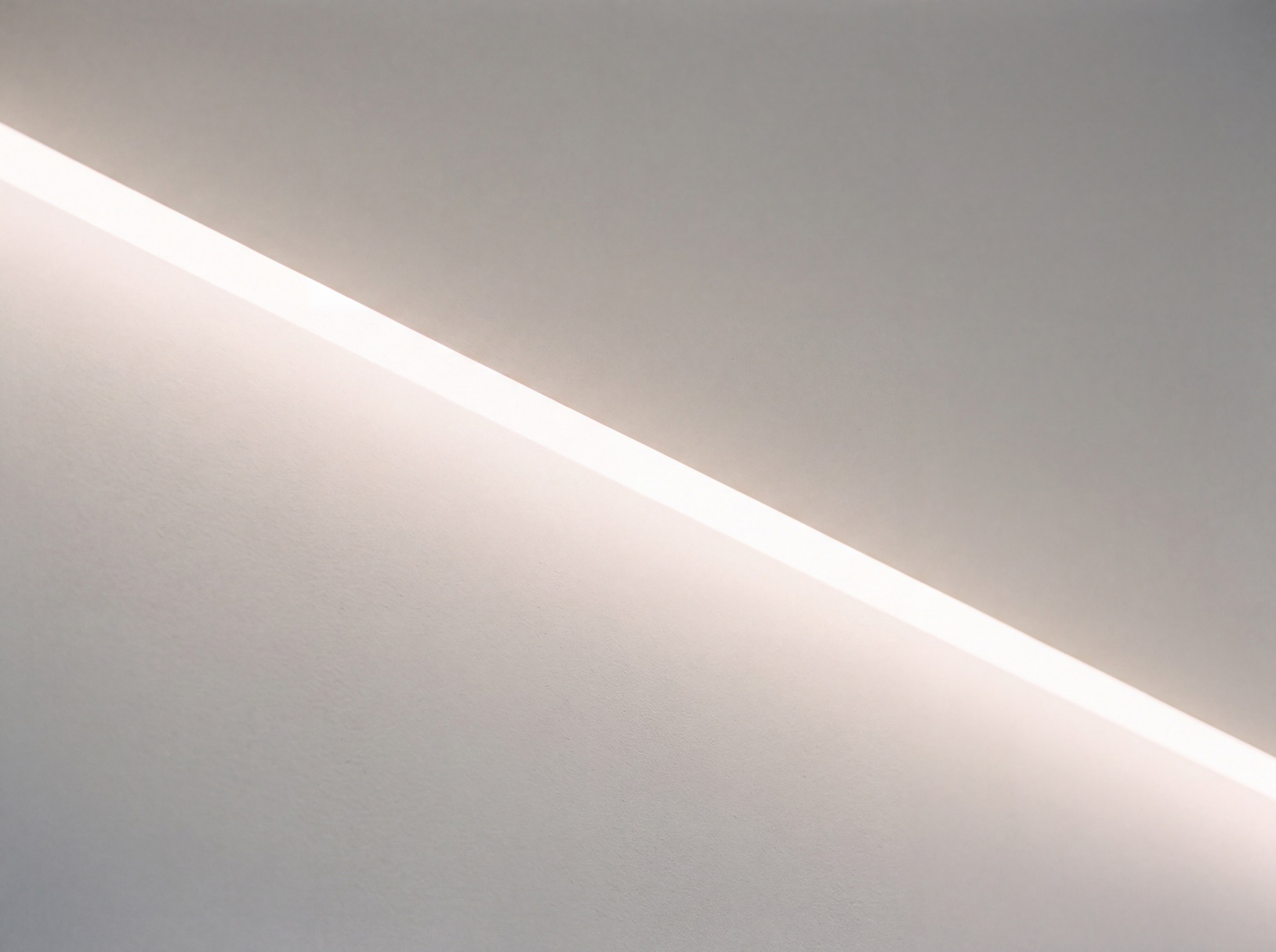 Macro of a ceiling cove slot done right: one unbroken even line of light, no visible emitter, no hot stripe