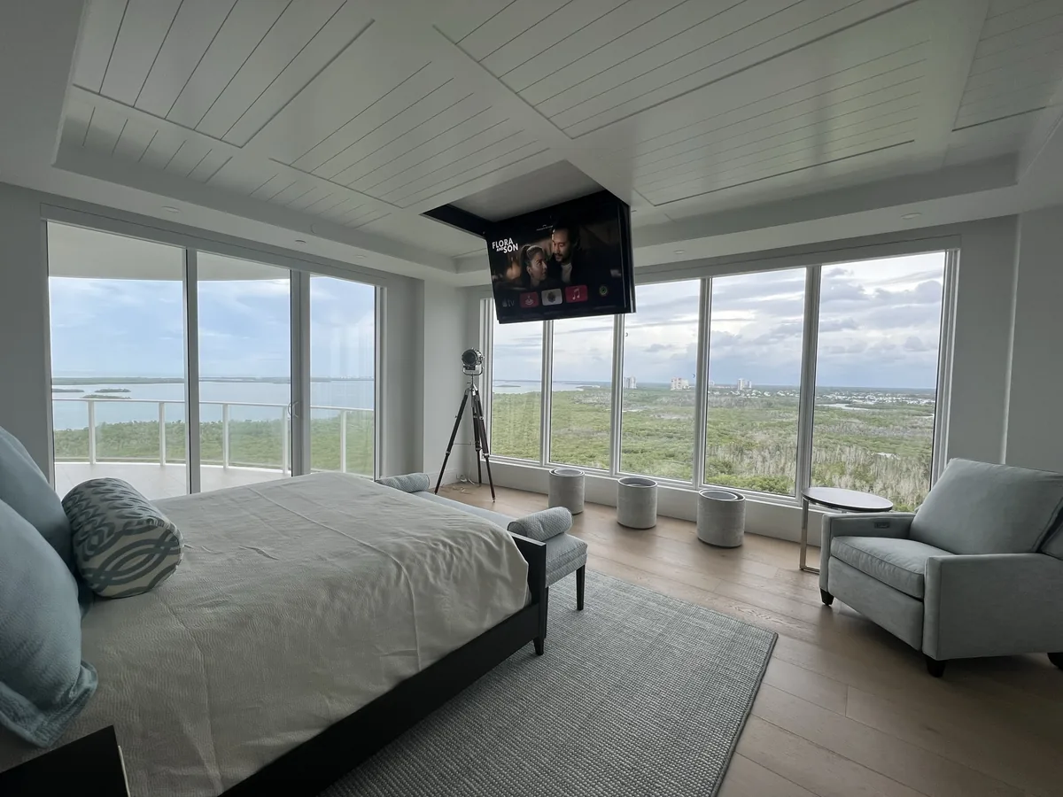 Bedroom with a ceiling mounted display and the shades up.