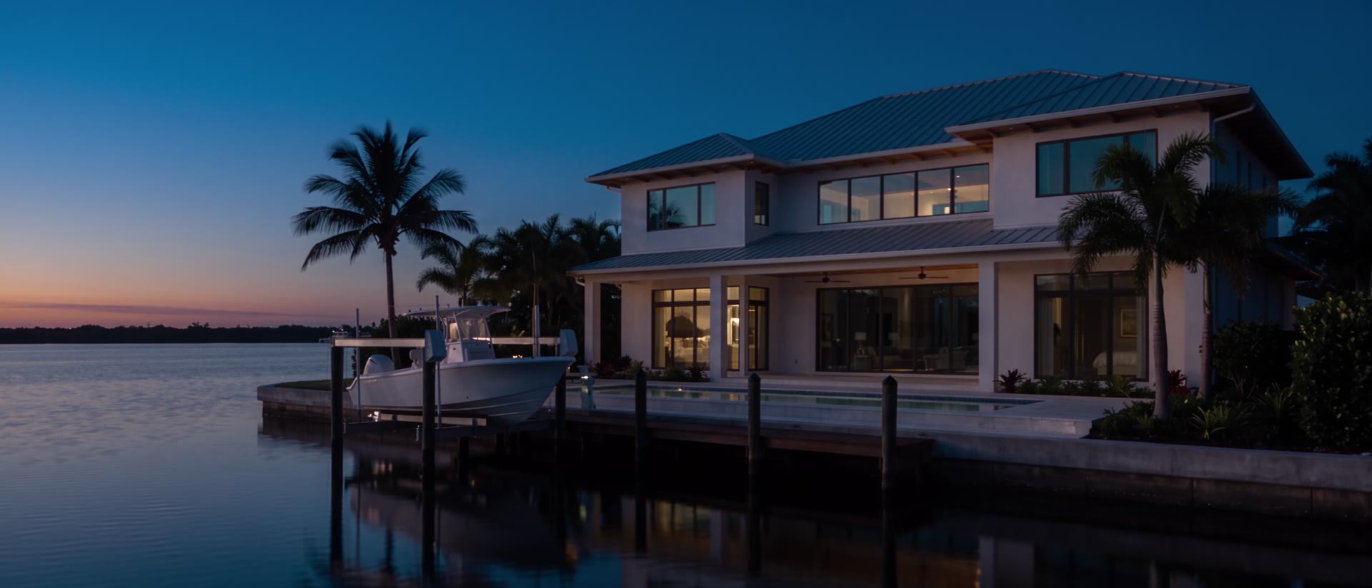 A canal house at blue hour, the lights coming up inside as the sky darkens.