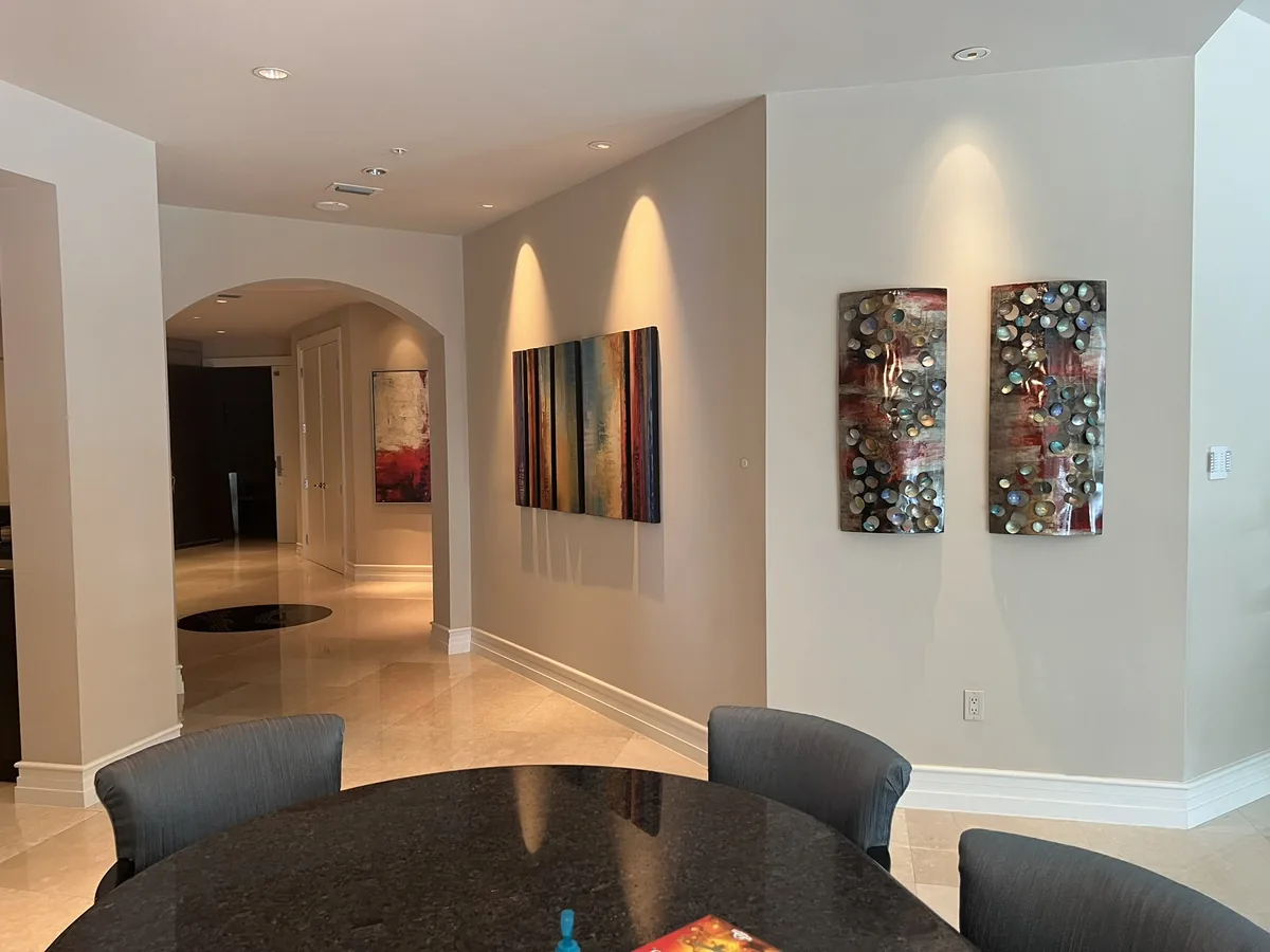 Hallway, each art panel lit by its own fixture.