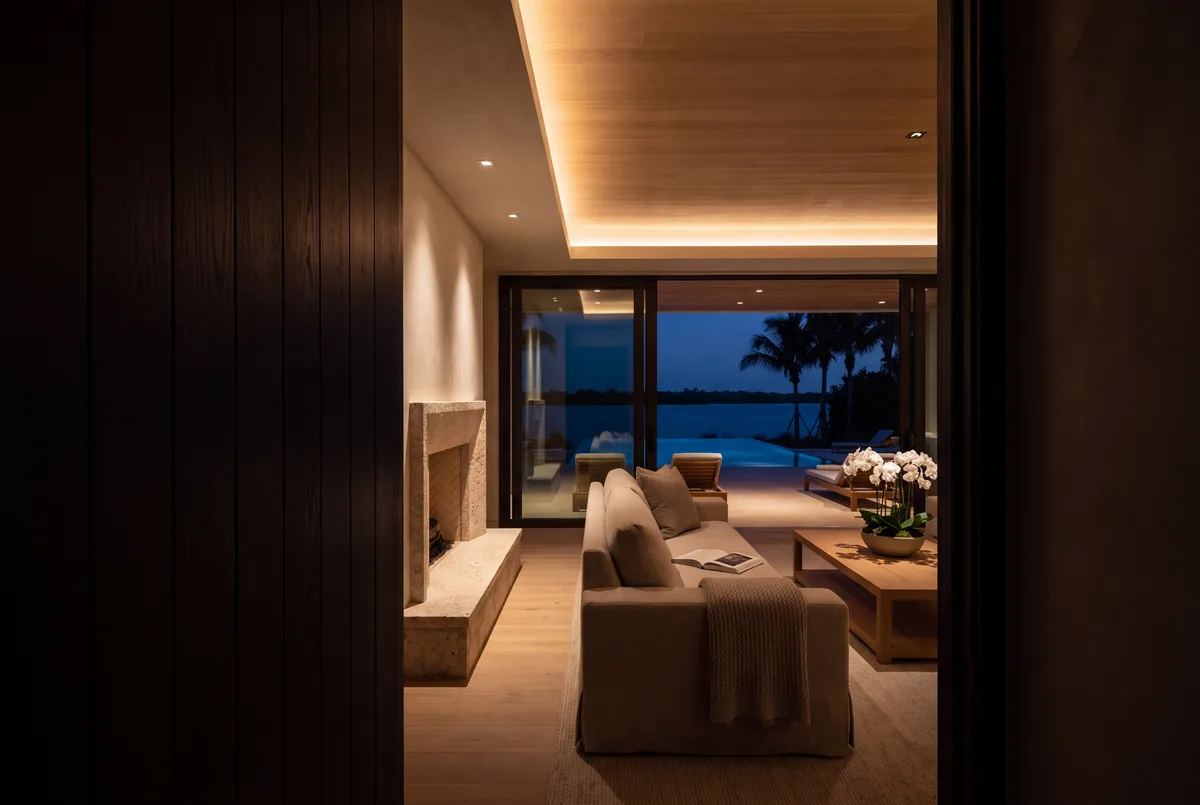 A living room on a low evening scene, seen from a dark hall.