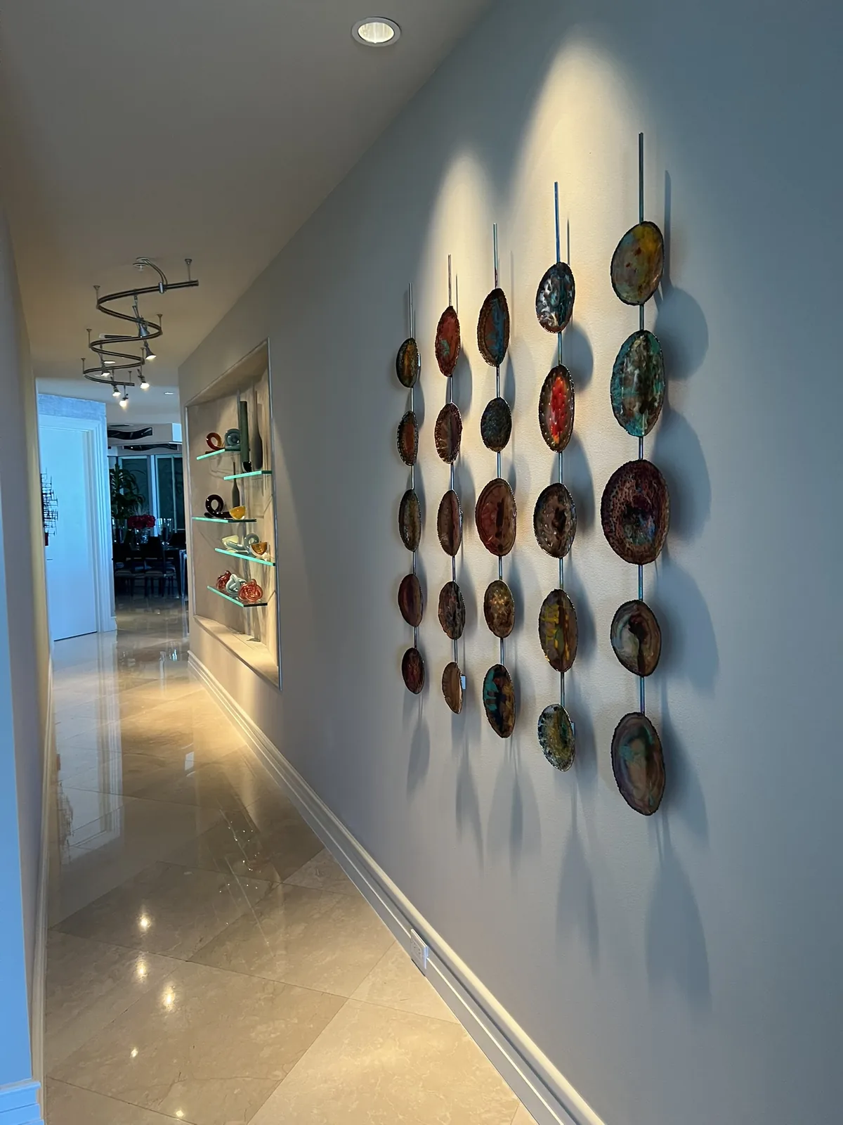 Corridor art wall, lit from recessed fixtures above it.